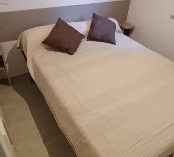 Chambre double avec lit, étagère et luminaires au camping eleganzia