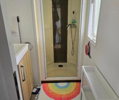 Salle de douche avec cabine et tapis coloré dans le mobile-home family’s dream Canet plage à pied