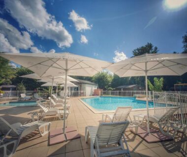 Piscine extérieure avec parasols et transats à l'hôtel gites le clos du moulin