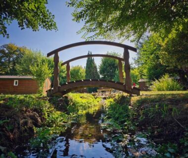 Pont en bois sur ruisseau dans le jardin de l'hôtel gites le clos du moulin
