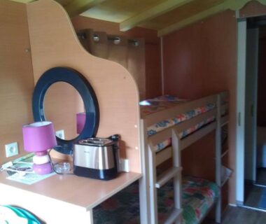 Intérieur avec lits superposés et coin kitchenette dans l'hébergement la Frégière Chalets