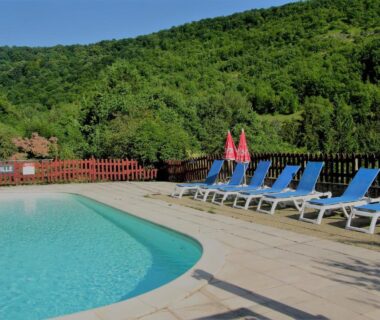 Piscine extérieure avec transats et parasols au camping la Frégière Chalets