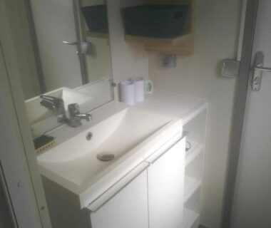 Salle de bains avec lavabo et miroir du camping la dune blanche