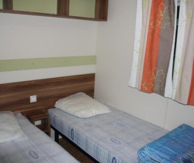 Chambre avec deux lits simples dans le mobil-home du Camping Des 3 Lacs