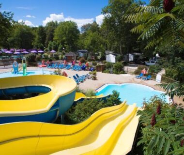 Piscine extérieure avec toboggans et transats au Camping Des 3 Lacs
