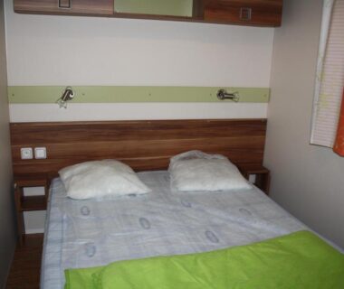 Intérieur chambre avec lit double dans le Camping Des 3 Lacs
