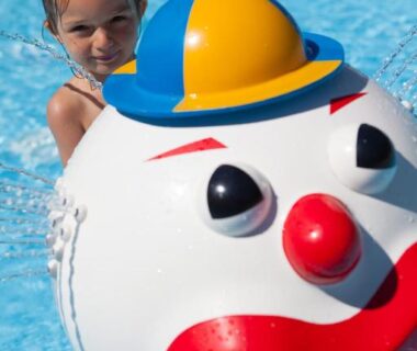 Piscine avec jeu d'eau clown et enfant au Camping Des 3 Lacs