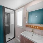 Salle de bains avec douche et lavabo au camping le Nomatitoz