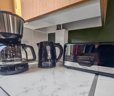 Coin cuisine avec cafetière bouilloire et grille-pain dans l'hébergement Le Nomatitoz