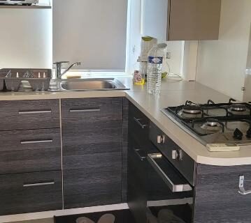 Cuisine équipée avec plan de cuisson et évier dans le mobil home au camping le lac des rêves
