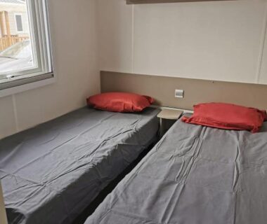 Chambre avec deux lits simples et fenêtre dans le lac des rêves camping 4 étoiles