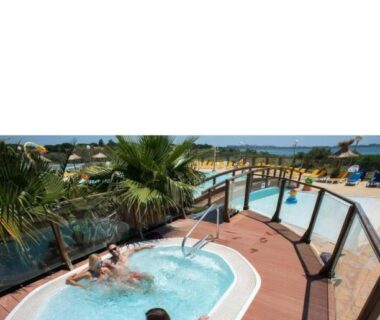 Terrasse avec jacuzzi et vue sur la piscine au camping le lac des rêves