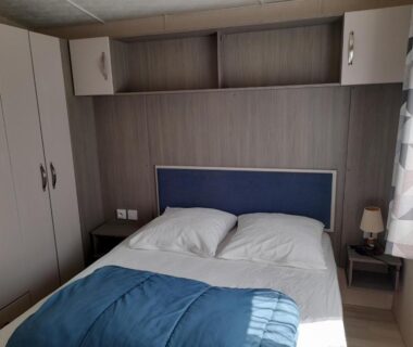 Chambre avec lit double et rangements dans le mobile home Le Victory