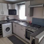Cuisine équipée avec plaque et machine à laver dans le mobile home Le Victory
