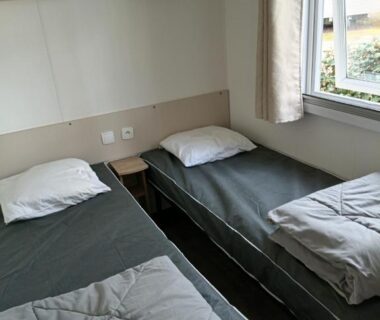Chambre avec deux lits simples près de la fenêtre au camping les Dunes de Contis