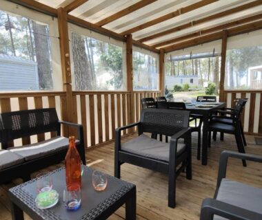Terrasse couverte avec salon table et bouteille de rosé au mobil-home Les Dunes de Contis