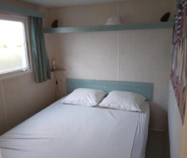 Chambre avec lit double et fenêtre au camping les marguerites