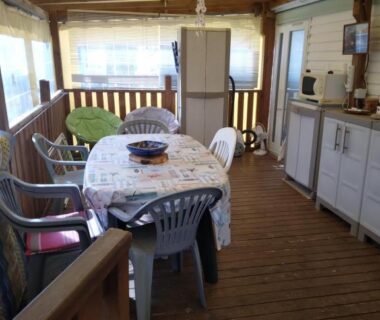 Terrasse couverte avec table et kitchenette dans le camping Les Marguerites