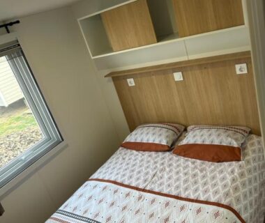 Intérieur chambre avec lit double et fenêtre dans le mobil-home du camping les sables du midi valras plage