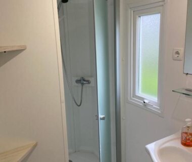 Salle d'eau avec cabine de douche et lavabo dans l'hébergement l'impasse de la tranquillité