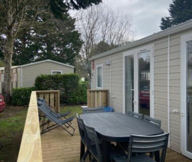 Terrasse en bois avec table chaises et transat du mobil-home l'impasse de la tranquillité