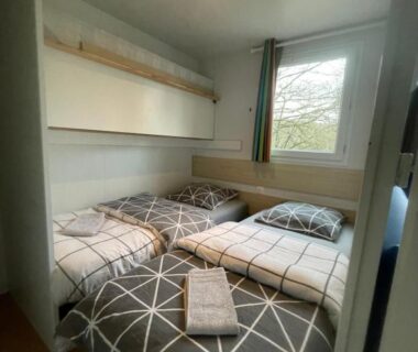 Chambre avec deux lits et fenêtre dans le logement au coeur de la nature
