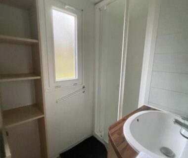 Salle de bain avec fenêtre douche et lavabo dans le logement au coeur de la nature