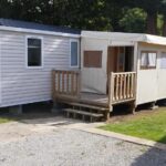 Allée de camping avec mobil homes et terrasse du mobil home 235