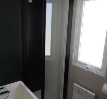 Salle d'eau avec douche et lavabo dans le mobil home 235