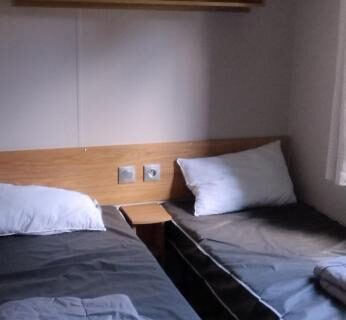 Chambre avec deux lits dans le mobil home 235