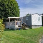 Sur la pelouse terrasse en bois et façade du mobil home 4 personne