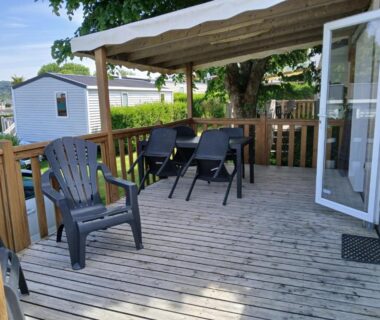 Terrasse en bois avec chaises longues et table sous auvent du mobil home 4 personne