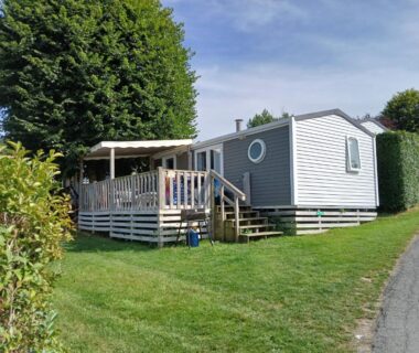 Sur la pelouse terrasse en bois et façade du mobil home 4 personne