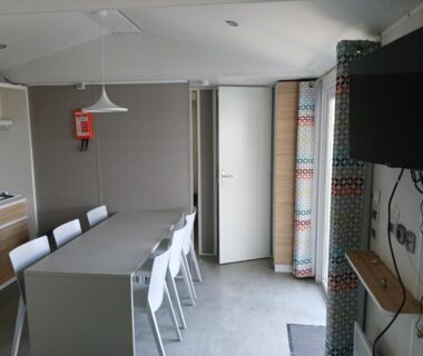 Intérieur avec table chaises et kitchenette dans le mobil home 4 personne