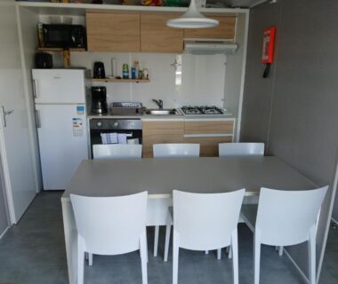 Dans le séjour table et cuisine équipée du mobil home 4 personne