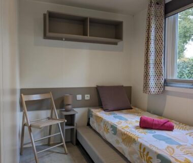 Chambre avec lit simple, chaise et fenêtre dans le mobil home 562 3 ch Siblu La Reserve