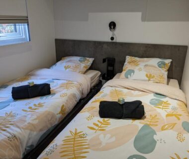 Chambre avec deux lits simples et serviettes dans le mobil home 562 3 ch Siblu La Reserve