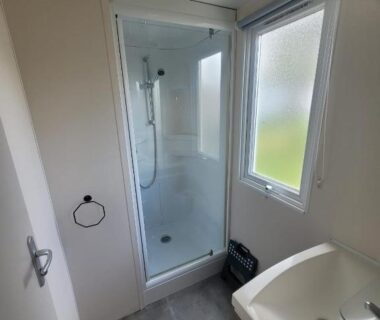 Salle de bain avec cabine de douche et lavabo du mobil home