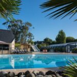 Piscine extérieure avec toboggan et abri vitré au camping Domaine de la Pommeraie à Trégunc