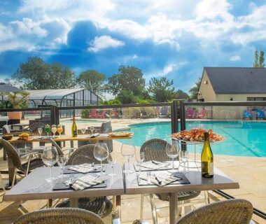 Terrasse avec tables et piscine extérieure du mobil home 6 pers au Domaine de la Pommeraie Trégunc Bretagne