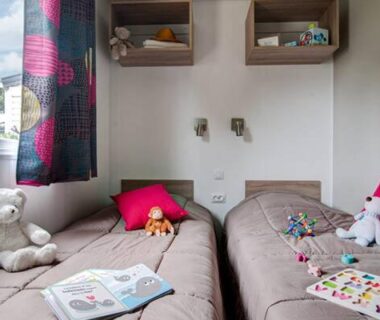 Coin nuit avec deux lits simples et peluches dans le mobil home 6 pers du Domaine de la Pommeraie