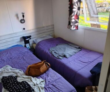 Chambre avec deux lits simples et fenêtre sur le camping du mobil home 6 personnes