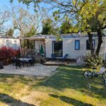 Terrasse avec table et vélos dans le jardin du mobil home 6 personnes