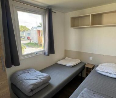 Chambre avec deux lits simples et fenêtre sur l'extérieur dans le mobil home 6 personnes accès direct plage