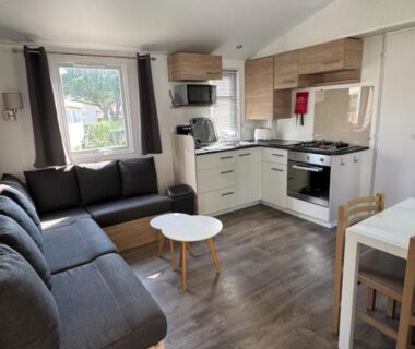 Séjour avec canapé et cuisine équipée dans le mobil home 6 personnes accès direct plage