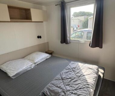 Chambre avec lit double et fenêtre dans le mobil home 6 personnes accès direct plage