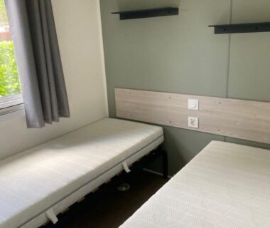 Chambre avec deux lits simples et étagères dans le mobil home 742