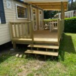 Terrasse en bois couverte avec table et chaises du mobil home 742