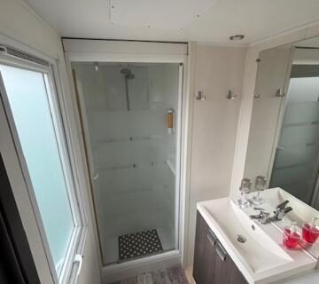 Salle de bain avec cabine de douche et lavabo dans le mobil home AU SOLEIL
