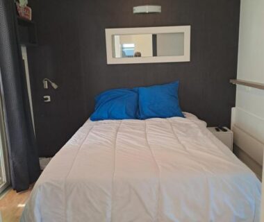Chambre avec lit double et coussins bleus dans le mobil home Confort Landes 38m2